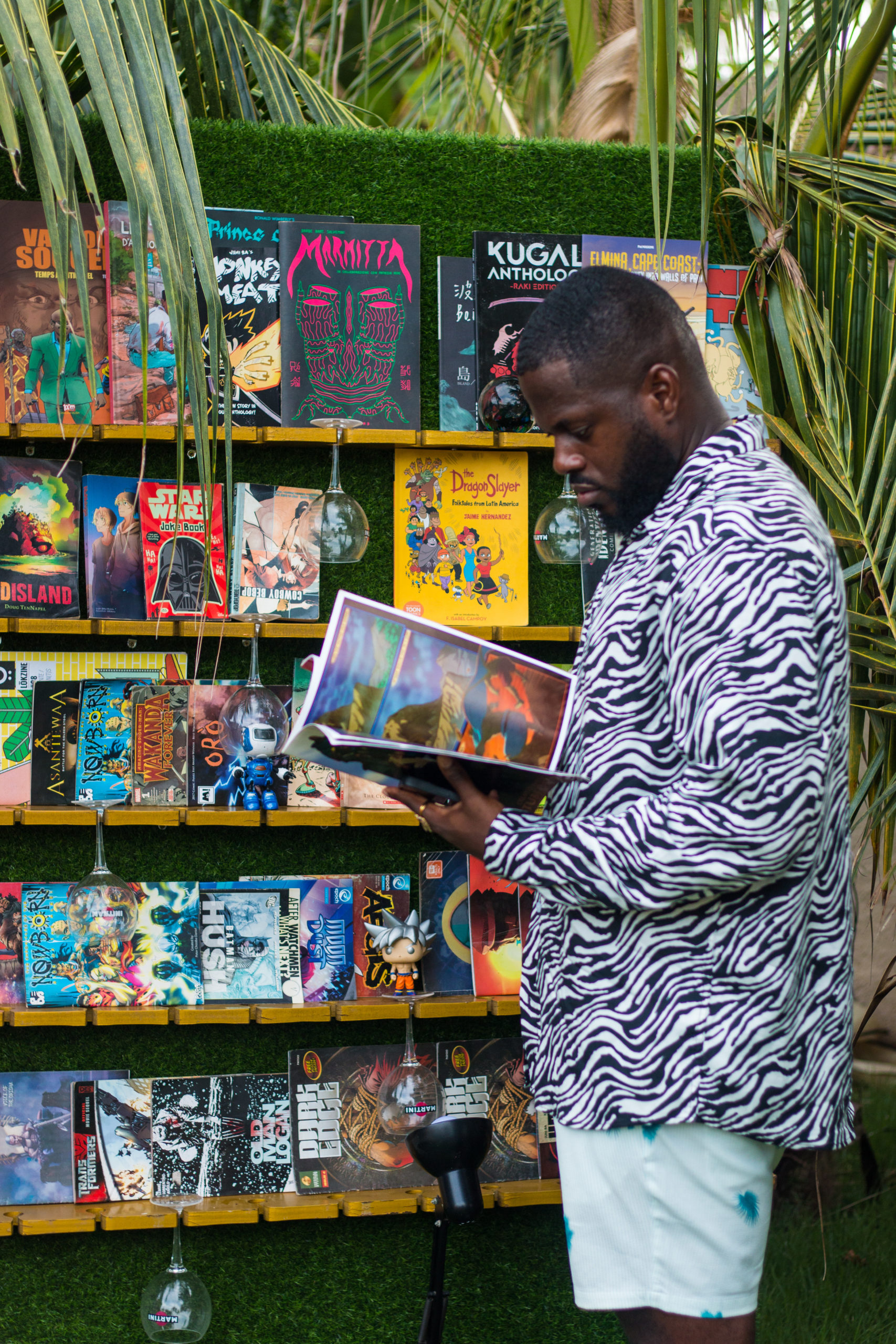 Ghanaian male comic book lover checking out comics at the Comic Bar at Frame x Frame Animation Nights